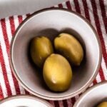 green round fruits on stainless steel bowl