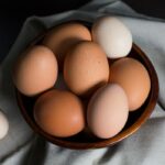 beige and white eggs on brown wooden bowl