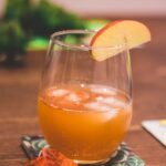 clear drinking glass with brown liquid and lemon