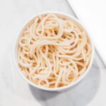 white noodles in bowl beside chopsticks